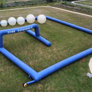 Inflatable structure for Zorb experience with large transparent balls and blue frame.